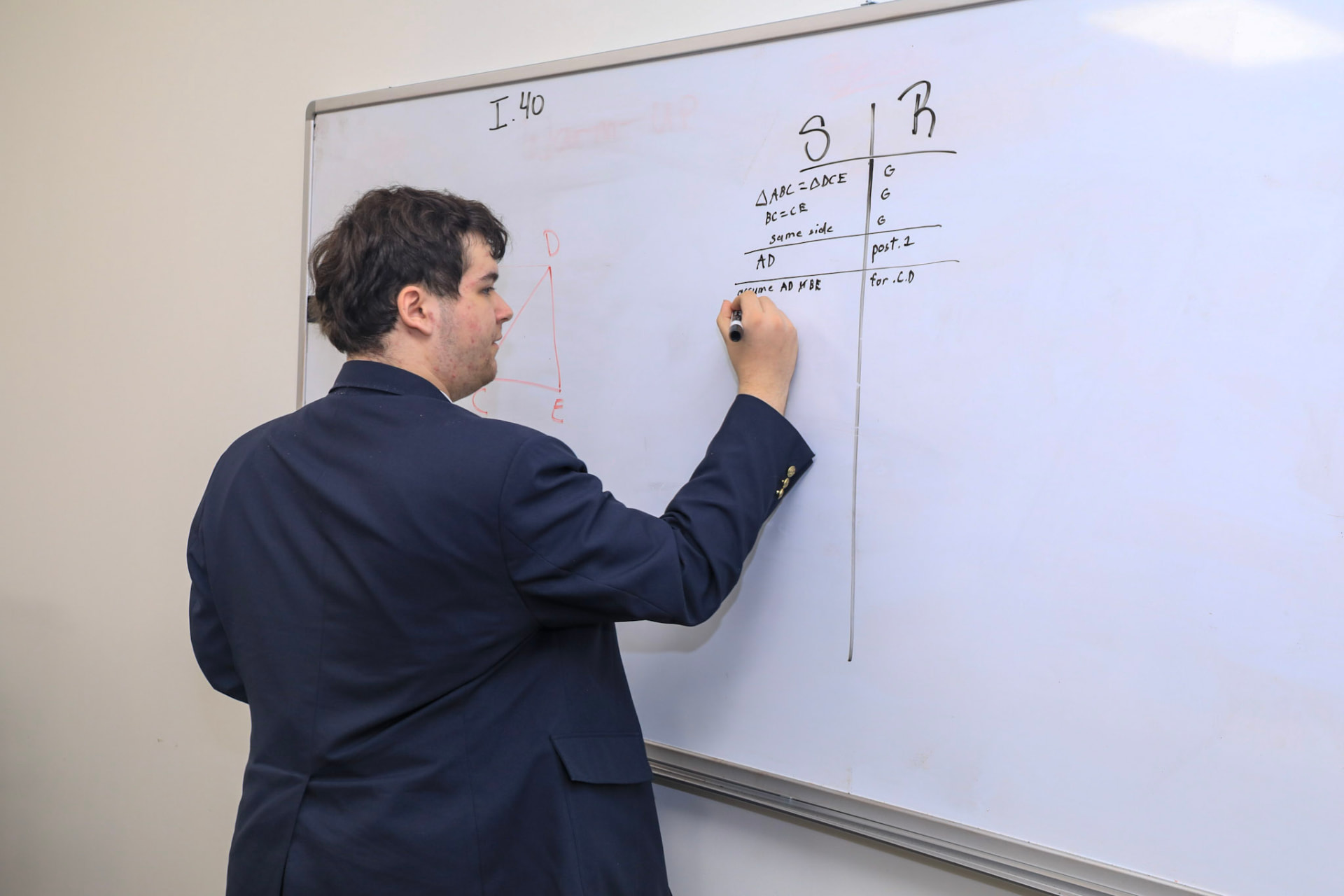A student working a Euclid proof at the whiteboard